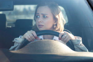 Bange volwassen vrouw achter het stuur; anxious woman driving the car